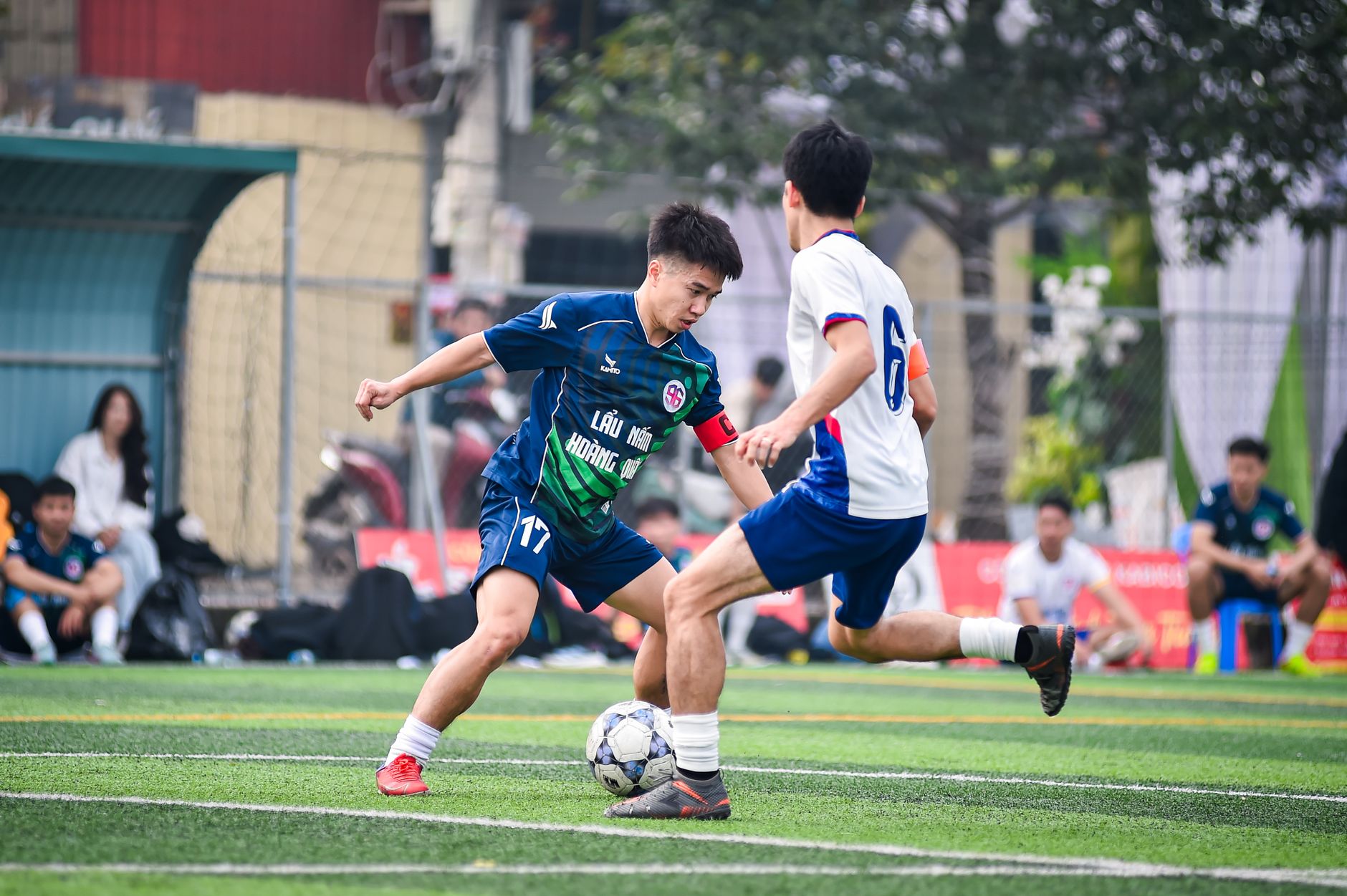 Dynamic shot of two soccer players competing fiercely on the field in Hà Nội.