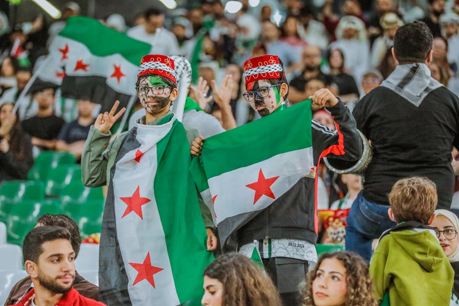 Supporters with Syrian flags at a sports event in Doha, capturing the vibrant and festive spirit.