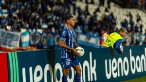 Football player in blue jersey readies for throw-in during live match.